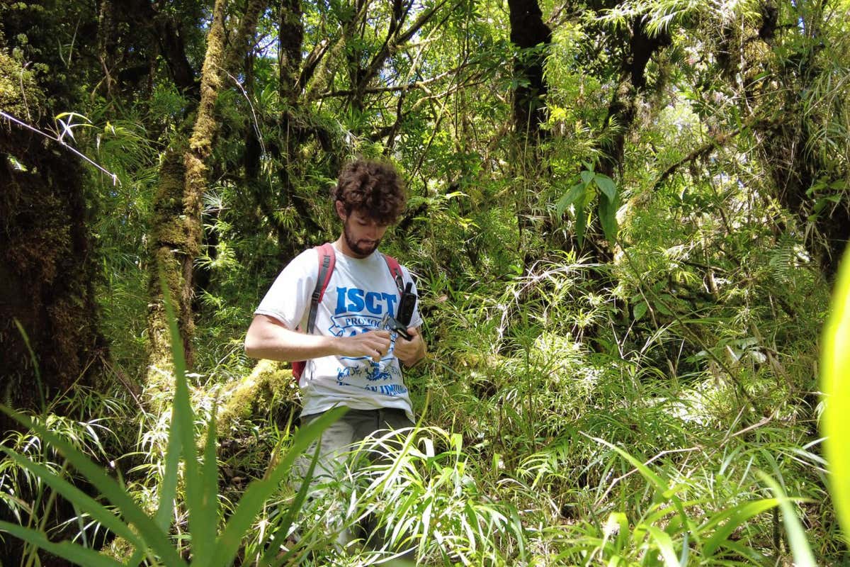 Giacomo Delgado man standing in a forest holding a microphone